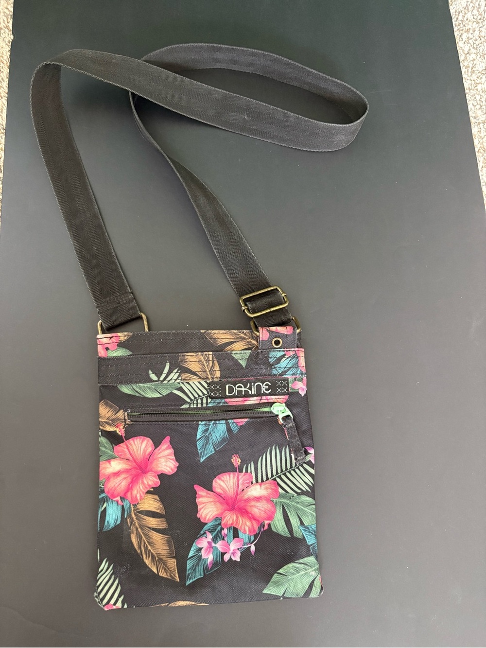 Dakine Black Tropical Hibiscus print Crossbody Bag with zipper pockets.